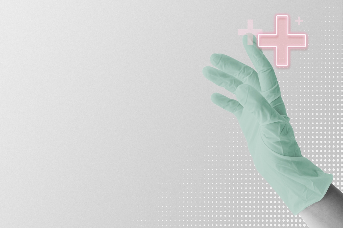 Dłoń lekarska w zielonej rękawiczce wskazująca na medyczny różowy krzyżyk